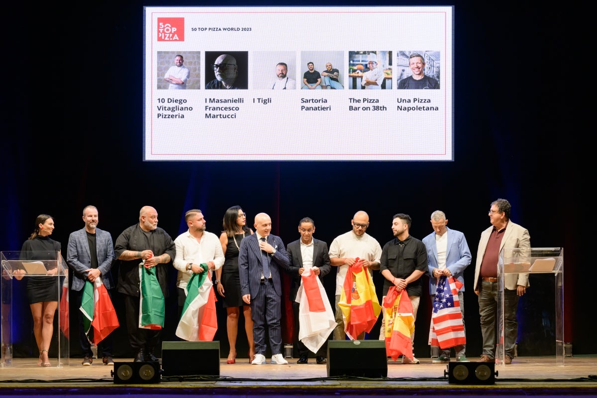Il palco con i protagonisti della top 10 di 50 Top Pizza World 2023 nel corso della cerimonia di premiazione