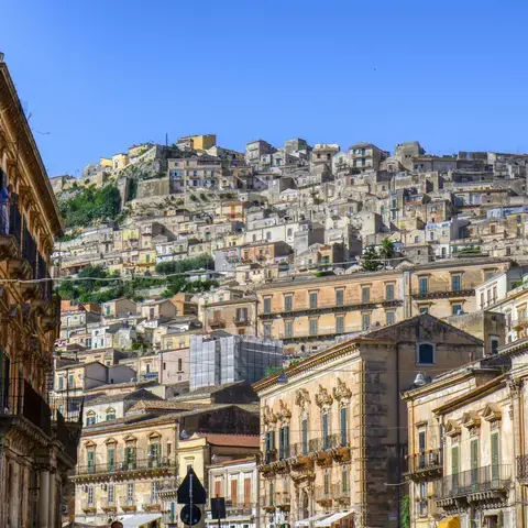 edificio in cemento marrone sotto il cielo blu durante il giorno