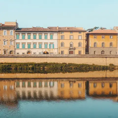 Edificio bianco in cemento vicino a uno specchio d’acqua durante il giorno.