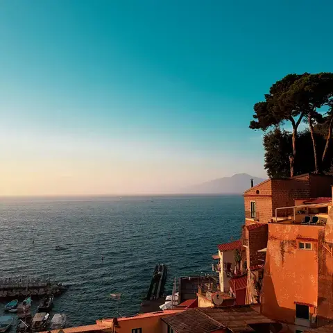 casa in cemento bianco vicino allo specchio d'acqua sotto il cielo blu durante il giorno