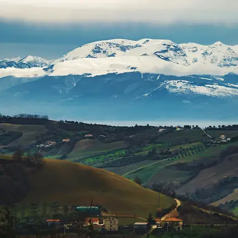 alberi e montagne verdi sotto nuvole bianche e cielo blu durante il giorno