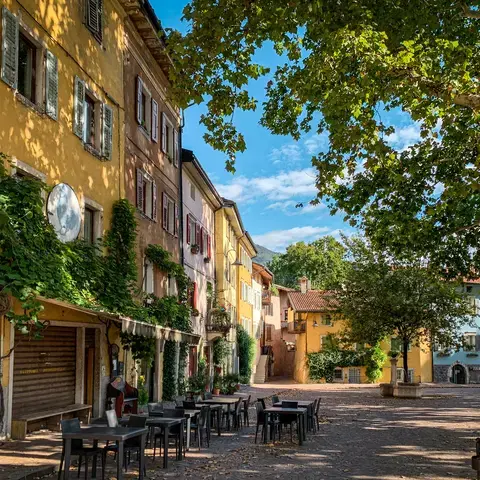 tavolo e sedie in legno marrone vicino a un edificio in cemento giallo durante il giorno