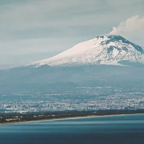 montagna innevata vicino allo specchio d'acqua durante il giorno