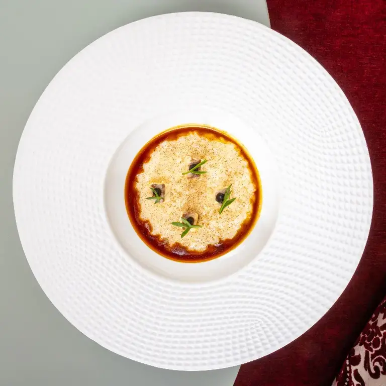 RISOTTO AL GRANA PADANO RISERVA, ANGUILLA AL VINO ROSSO, CARDAMOMO E AGLIO NERO