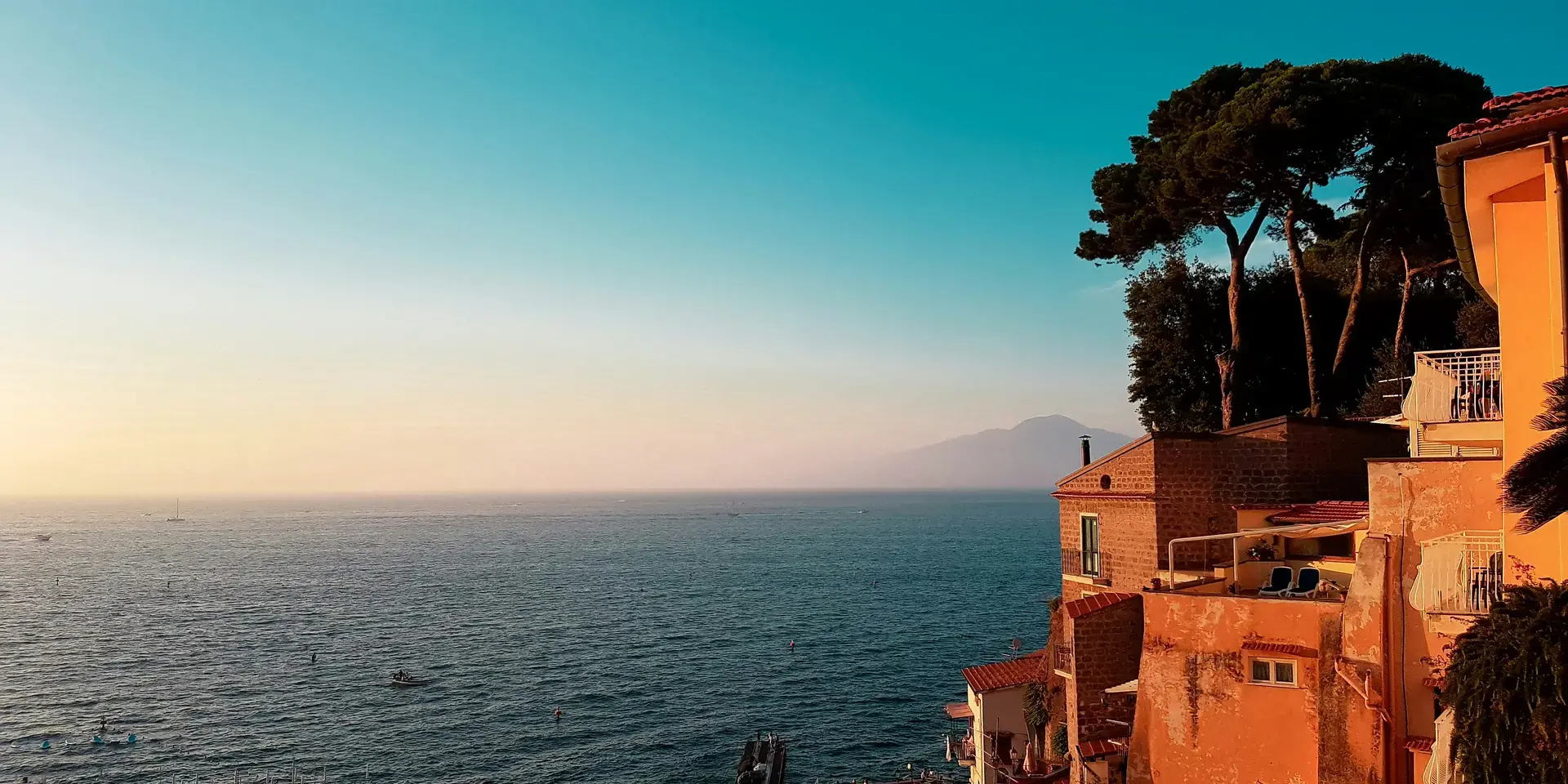 casa in cemento bianco vicino allo specchio d'acqua sotto il cielo blu durante il giorno