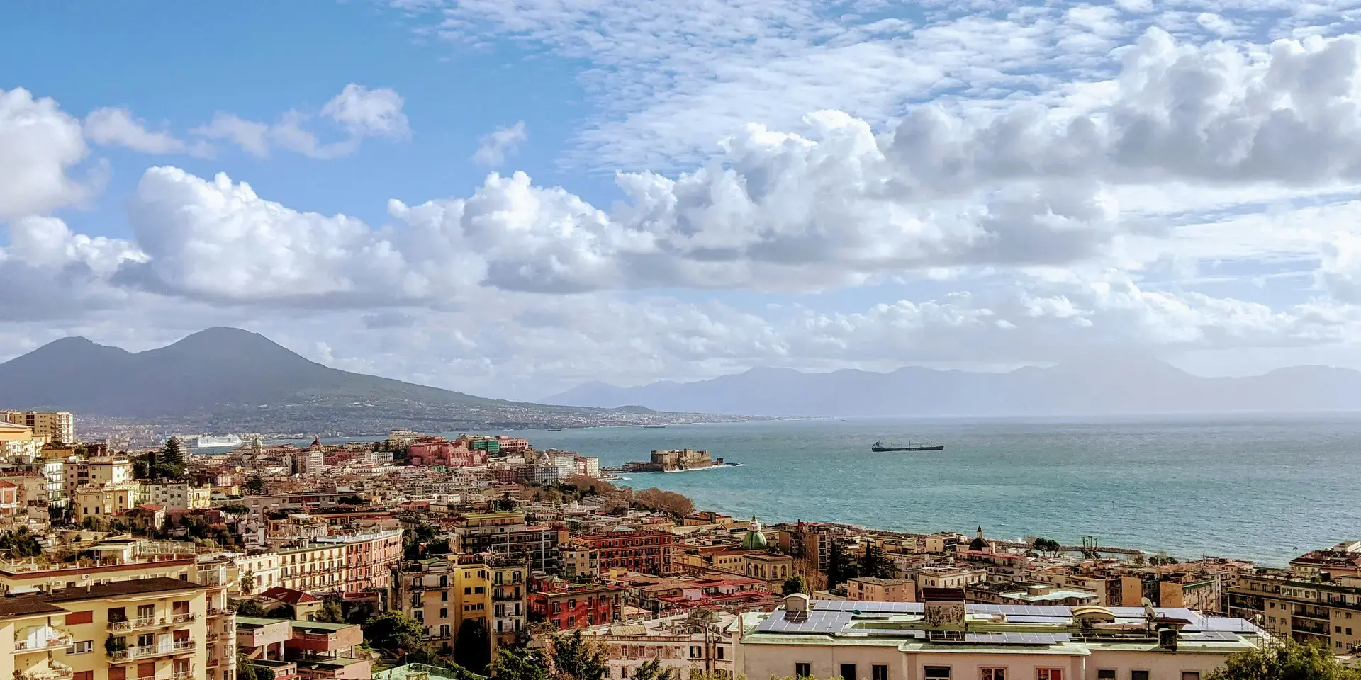 Edifici della città vicino al mare sotto le nuvole bianche ed il cielo blu durante il giorno