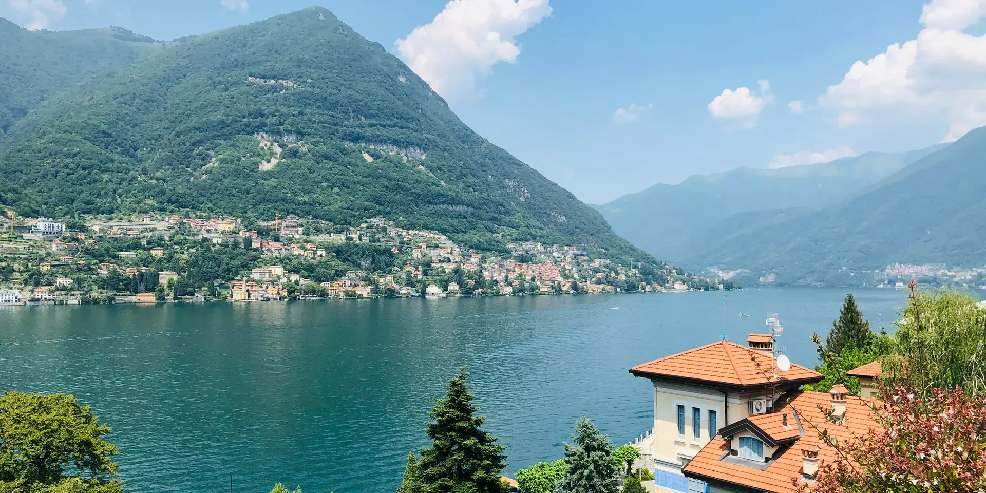 Casa in cemento bianco e marrone vicino allo specchio d'acqua durante il giorno