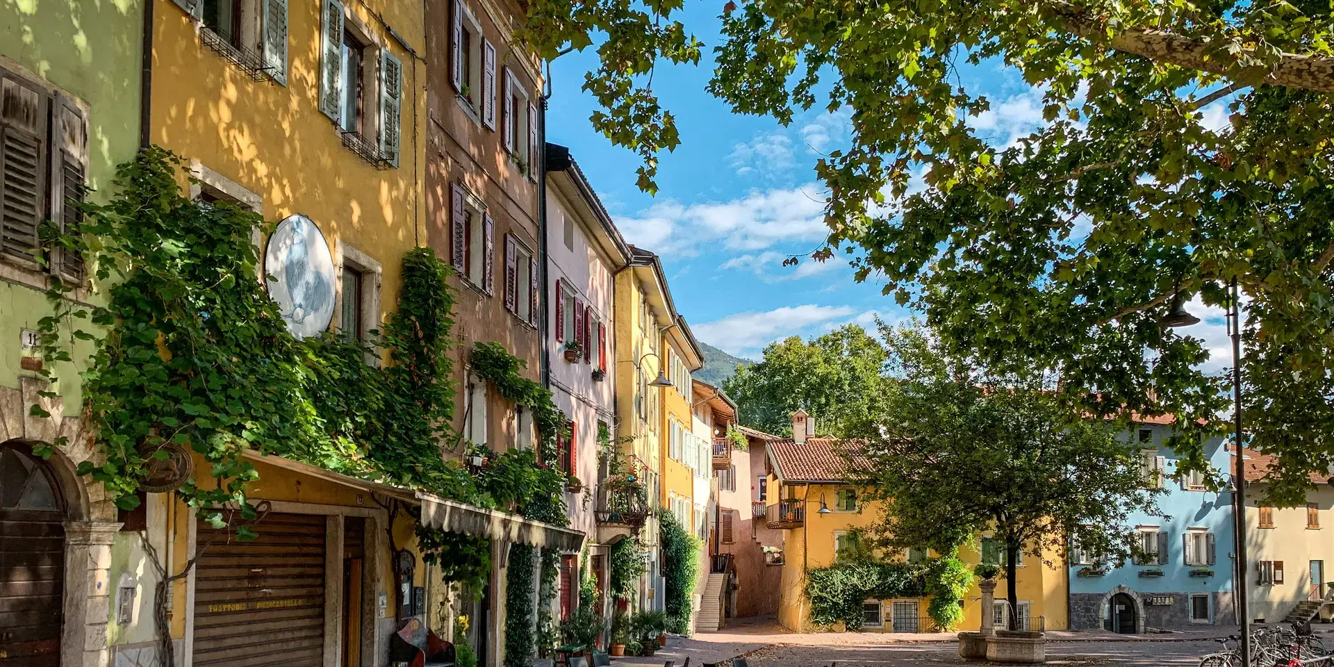 tavolo e sedie in legno marrone vicino a un edificio in cemento giallo durante il giorno