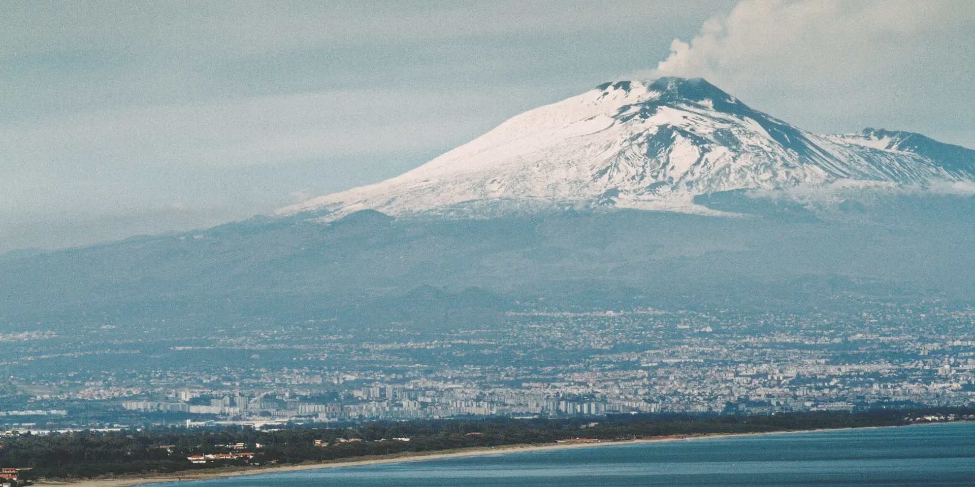 montagna innevata vicino allo specchio d'acqua durante il giorno