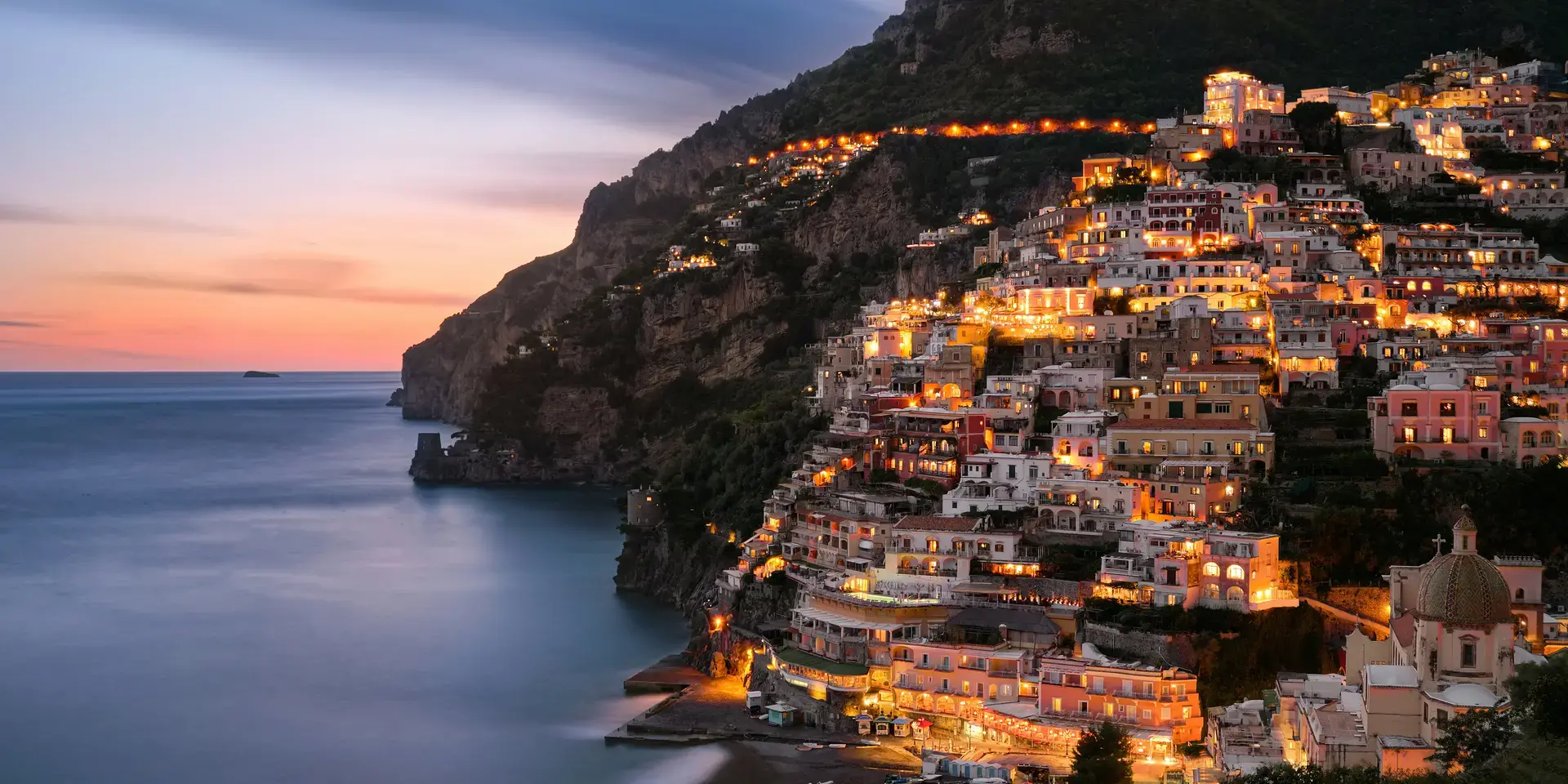 Edifici della città sulla montagna vicino allo specchio d'acqua durante il giorno