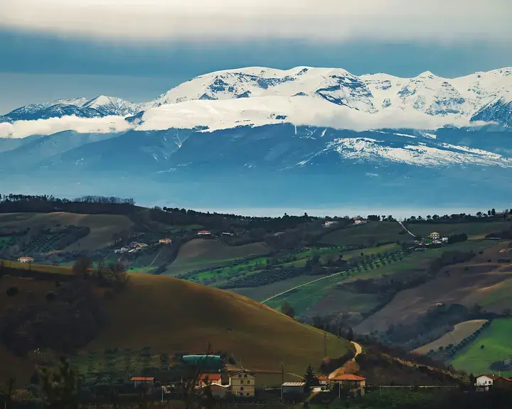 alberi e montagne verdi sotto nuvole bianche e cielo blu durante il giorno